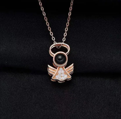 An elegant pendant necklace with a copper angel-wing design that projects the phrase 'I Love You' in 100 languages when illuminated.