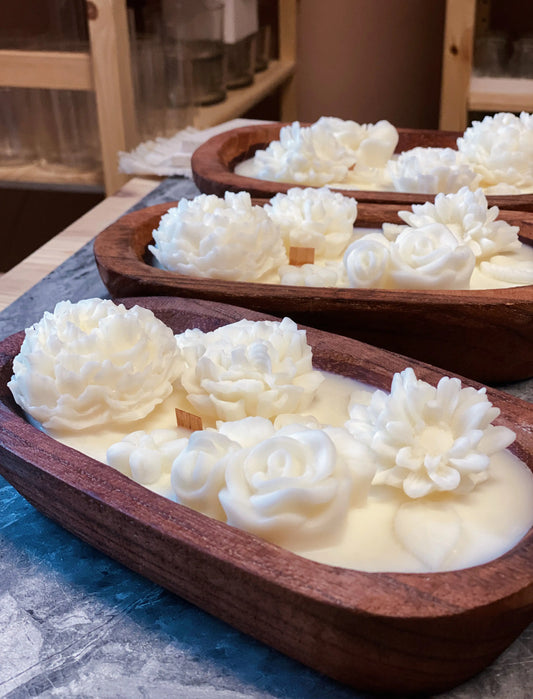 Wooden bowl candles with floral designs on top, made of natural soy wax with wooden and cotton wicks.