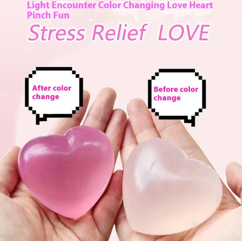 Two heart-shaped color-changing maltose candies held in hands, one pink and one clear, demonstrating the color change effect.