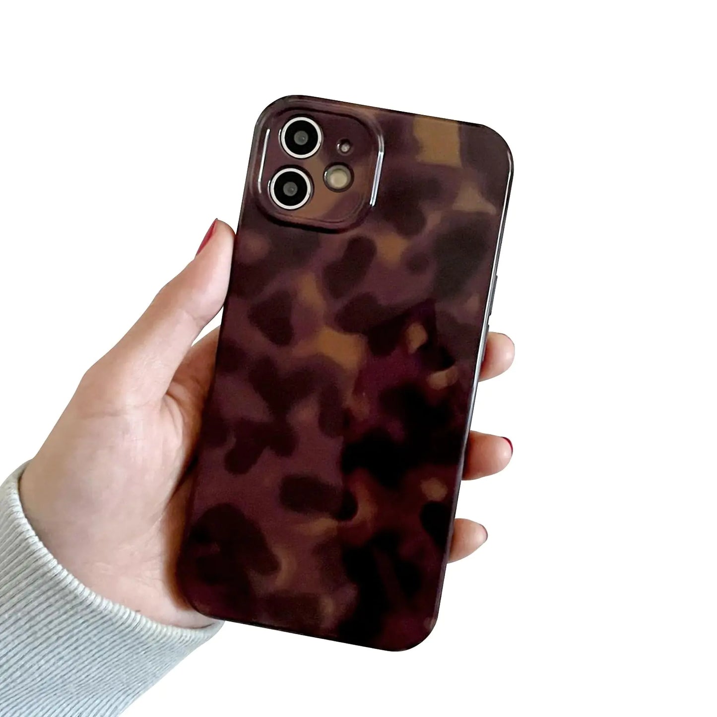 A hand holding a iPhone 14 case with a brown amber animal print design.