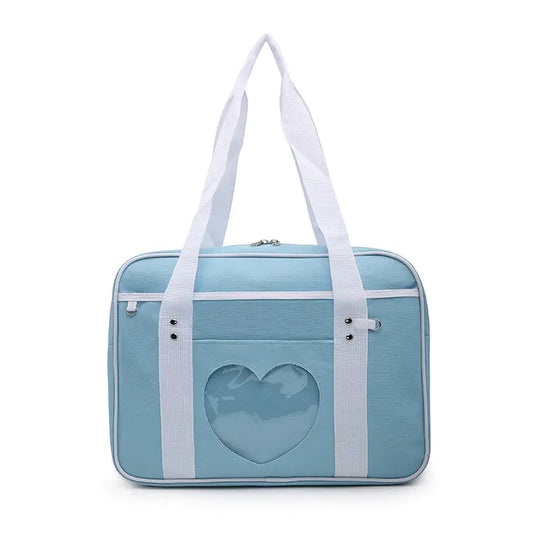 A blue shoulder tote bag with a white heart pattern on the front, featuring white straps and a zipper closure.