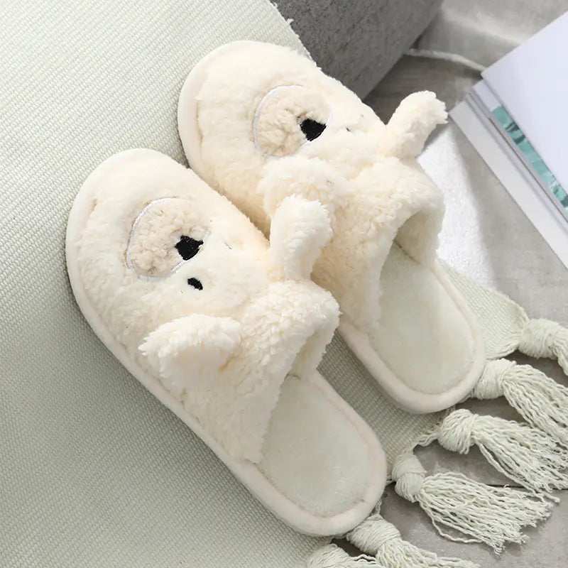 A pair of beige plush slippers designed to resemble a bear, with a round toe shape and a non-slip sole.