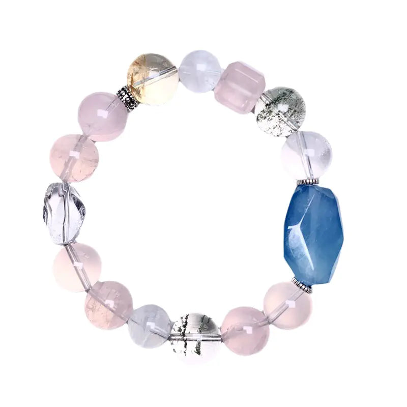 A bracelet with irregular shaped aquamarine and pink crystals, with a mix of silver and gold toned accents.