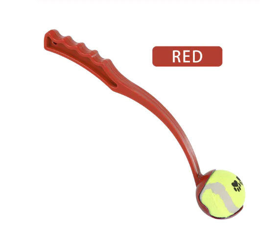 A red dog ball launcher with an ergonomic handle, designed to throw a tennis ball for fetch.