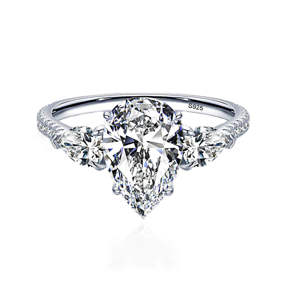 A sterling silver ring with a drop-shaped purple diamond centerpiece and accent diamonds around it.