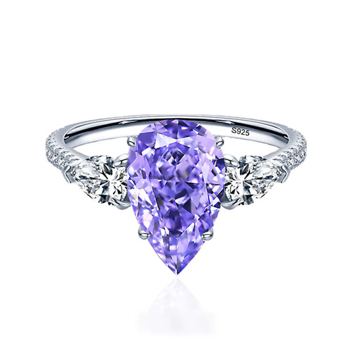 A sterling silver ring with a drop-shaped purple diamond centerpiece and accent diamonds around it.