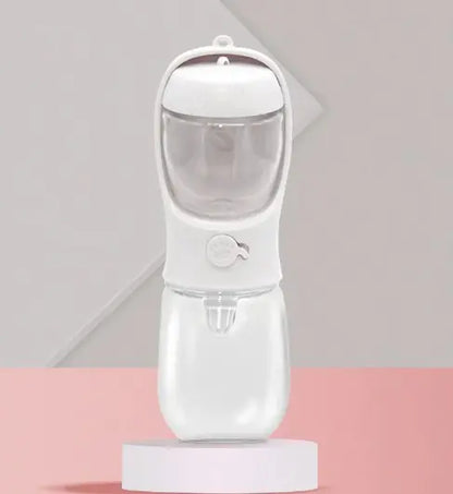 A portable dual-use dog drinking cup in pink color, with a water reservoir on top and a detachable compartment at the bottom for storing snacks.