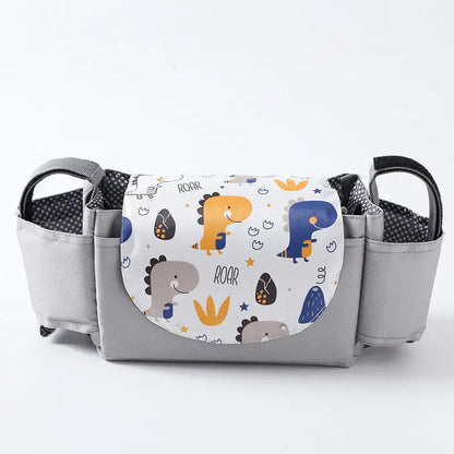 Gray diaper bag with dinosaur-themed pocket on a white background