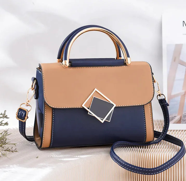 A two-tone elegant sling bag with blue and beige colors, featuring a leather-like texture, a structured design, and a metallic buckle.