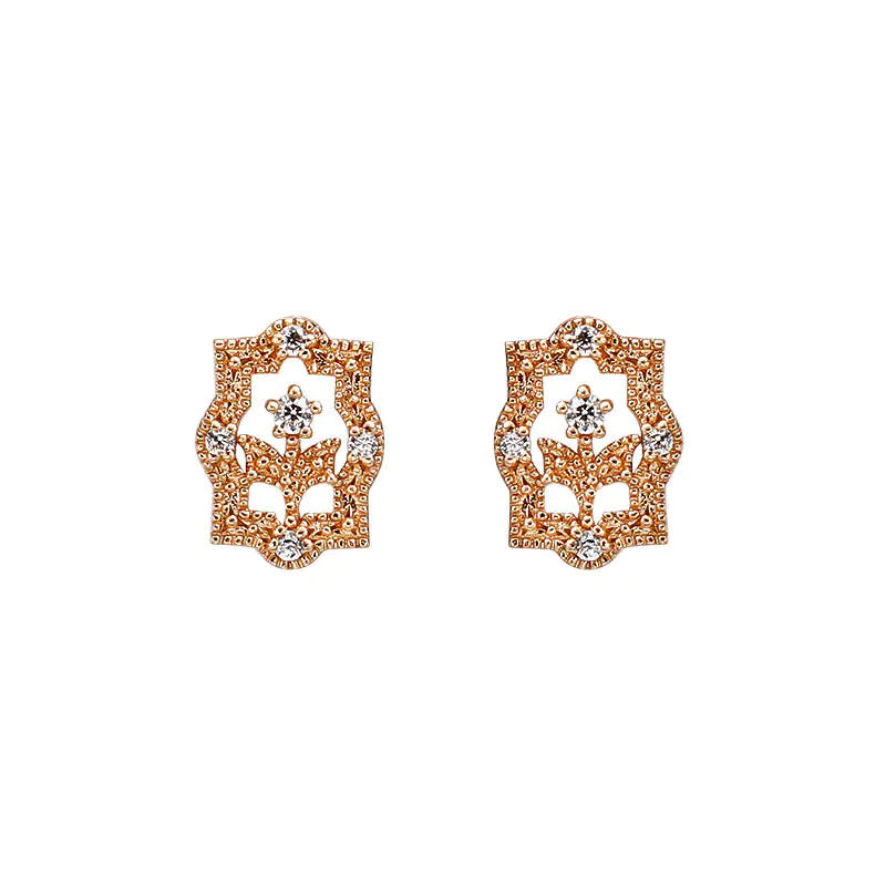 A pair of rose gold-colored earrings with a floral design and zircon embellishments.