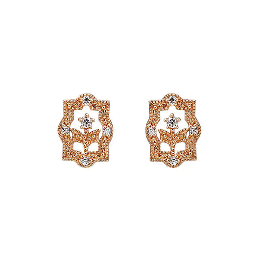A pair of rose gold-colored earrings with a floral design and zircon embellishments.
