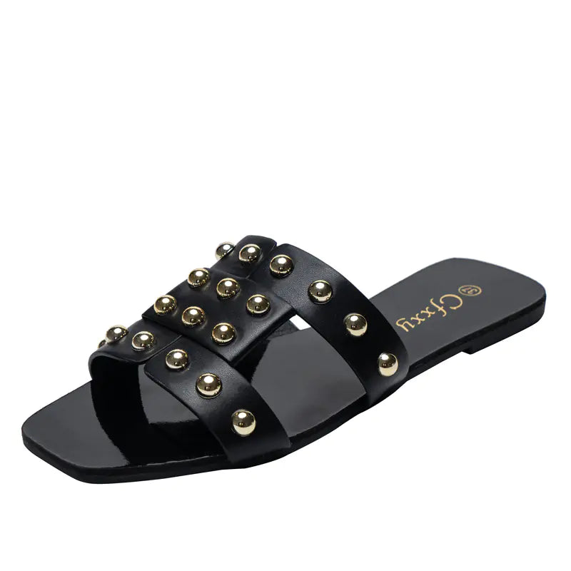 A pair of brown flat sandals with metal rivet accents on a black rubber sole, designed for women's casual wear.