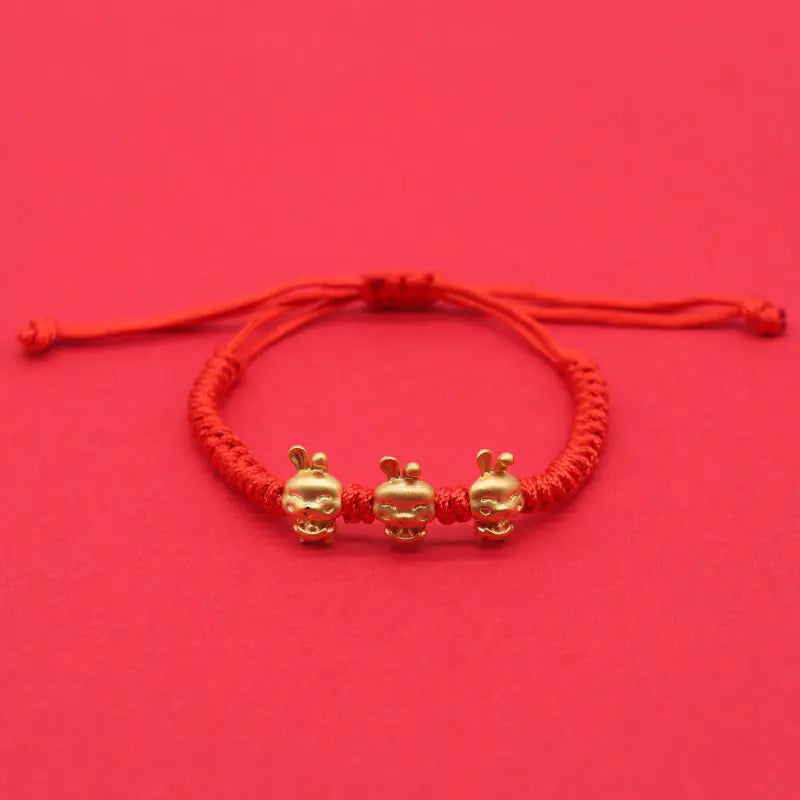 A simple woven hand rope bracelet with a floral shape and multicolored threads on a red background.