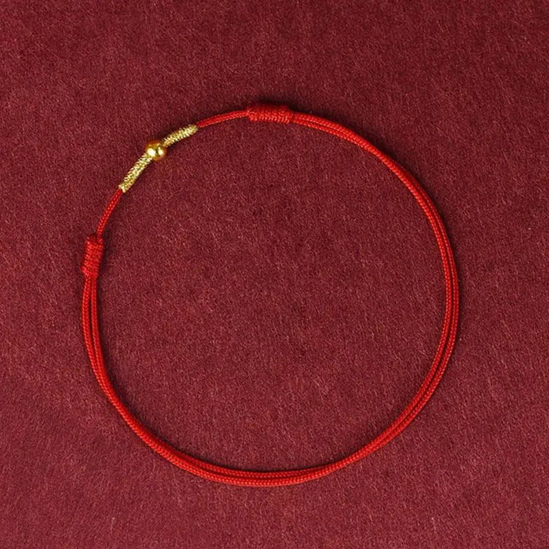 A simple woven hand rope bracelet with a floral shape and multicolored threads on a red background.