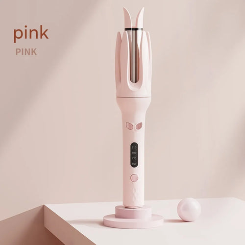 A pink full-automatic hair curler standing upright on a stand with a closed curling chamber, displaying its body and temperature control panel.
