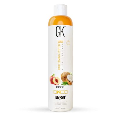 Bottle of GK HAIR Global Keratin The Best COCO smoothing keratin hair treatment with images of coconut and peach on the label.