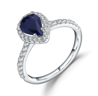 A sterling silver ring with a central diamond inlay surrounded by smaller gemstone inlays on the band.