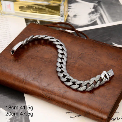 A silver fashion bracelet with a glossy snake pattern, displayed on a brown leather surface.