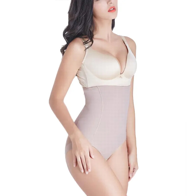 A person wearing high-waist shaping pants in a beige color, designed to provide a slimming effect and accentuate curves.