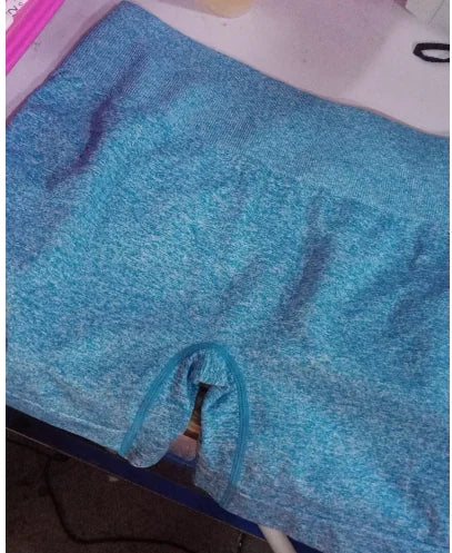 A pair of high-waisted blue yoga shorts made from a soft fabric, displayed in a reclined position.