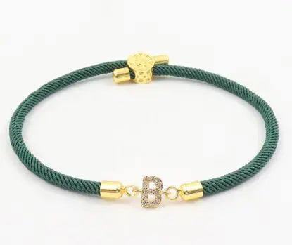 A dark green initial letter charm bracelet with a gold-colored clasp and a charm in the center.