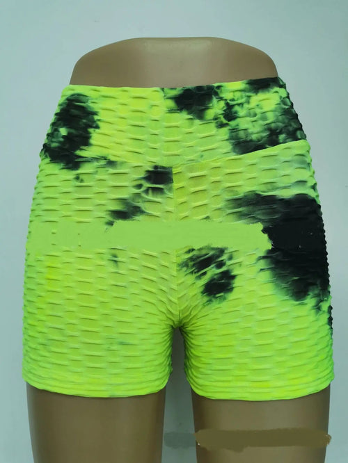 A pair of bright yellow yoga pants with a black floral ink pattern