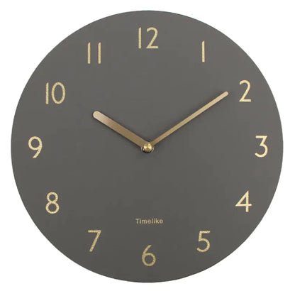 An oversized wall clock with a brown leather shell and a clear mirror dial, featuring black numbers and gold hands.