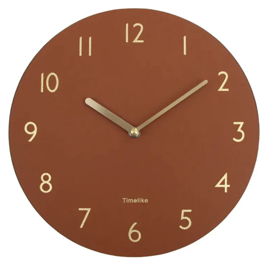 An oversized wall clock with a brown leather shell and a clear mirror dial, featuring black numbers and gold hands.