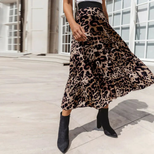 A woman wearing a leopard print A-line mini skirt with a pleated design, paired with black ankle boots.