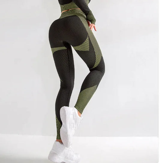 A person wearing high-waisted, tight-fitting green and black yoga pants with white sneakers.