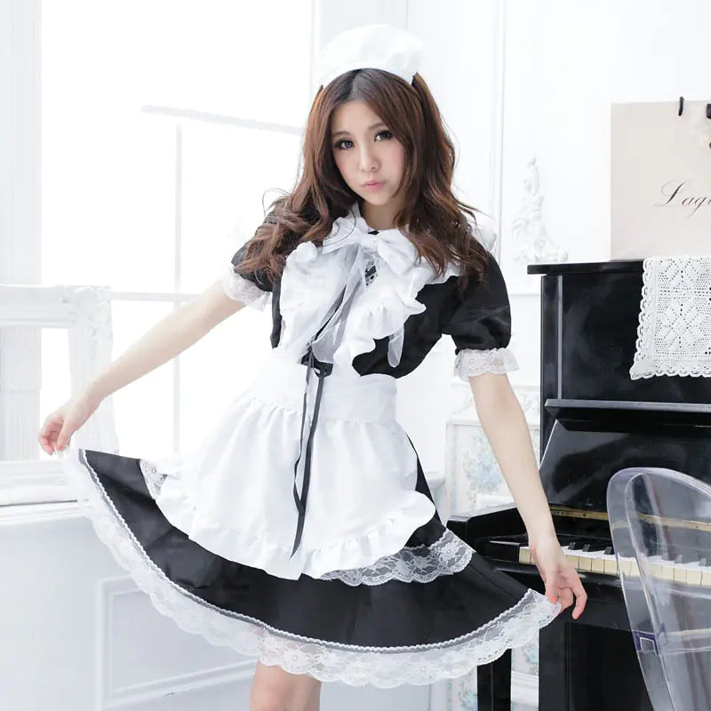 A person wearing a black and white maid cosplay outfit with lace and ribbon details.