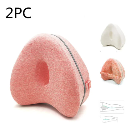 A love-shaped memory foam pillow with a gray cover, displayed in a neutral setting with variants in color and packaging.