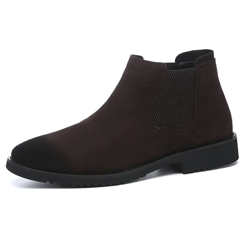 A pair of black high-top leather Chelsea ankle boots with a pointed toe and flat heel.