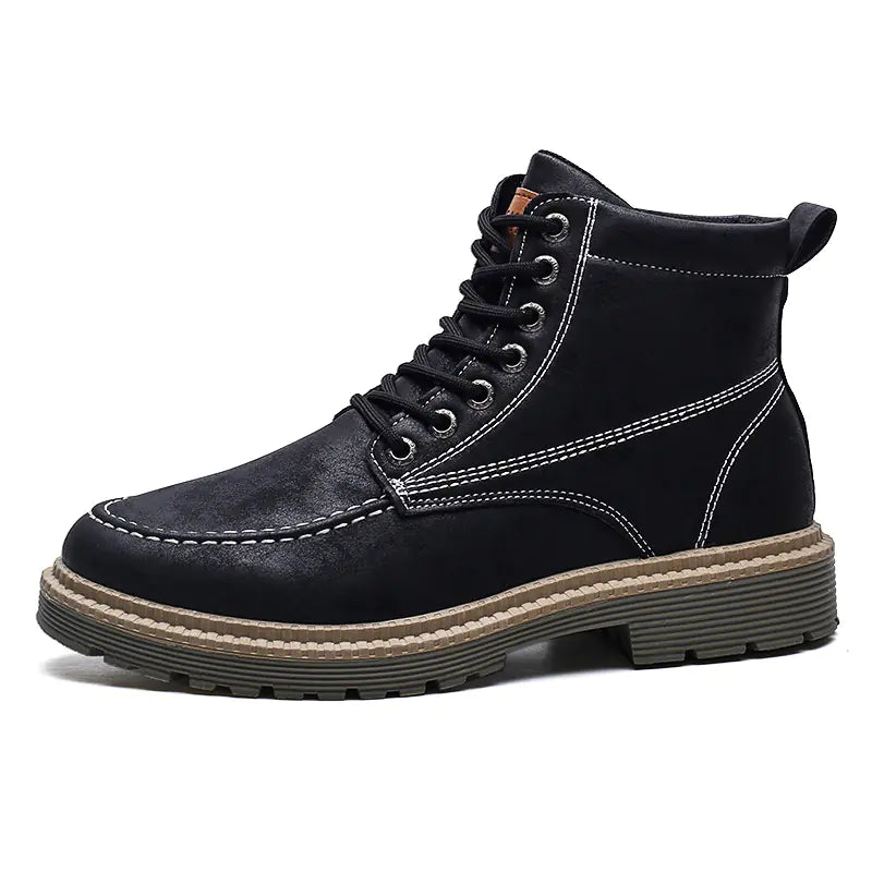 A pair of black men's casual leather boots with lace-up closure and flat heels, worn with rolled-up jeans.