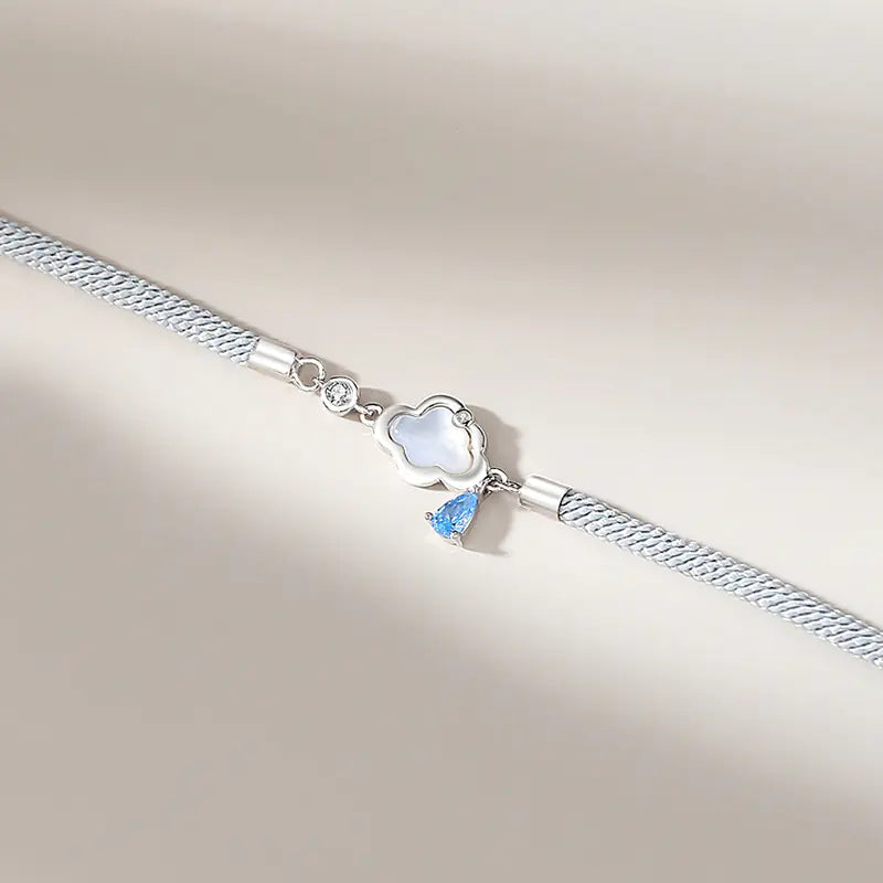 Two sterling silver bracelets, one with a cloud-shaped charm and a blue crystal, and the other with a black and white design featuring a star.