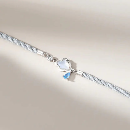Two sterling silver bracelets, one with a cloud-shaped charm and a blue crystal, and the other with a black and white design featuring a star.