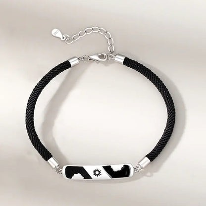 Two sterling silver bracelets, one with a cloud-shaped charm and a blue crystal, and the other with a black and white design featuring a star.