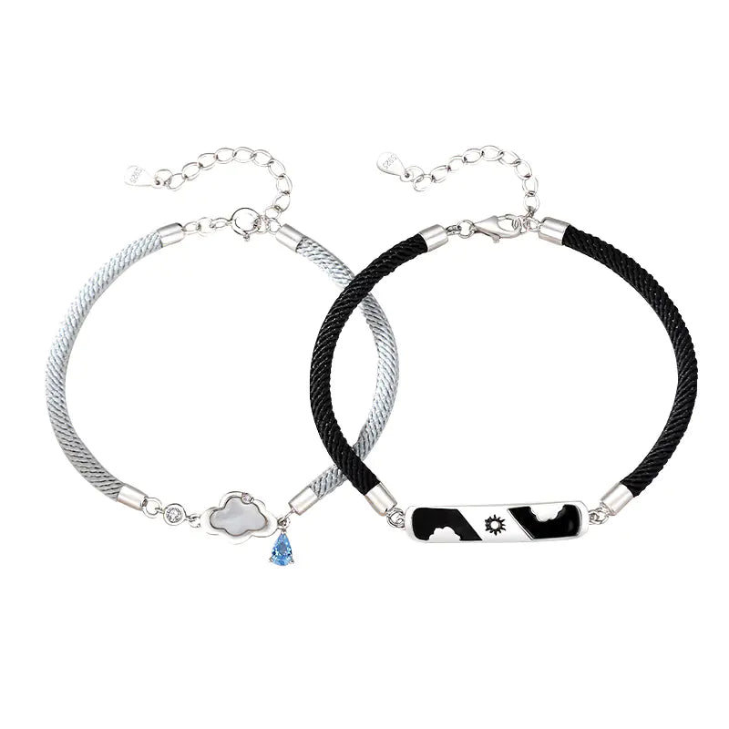 Two sterling silver bracelets, one with a cloud-shaped charm and a blue crystal, and the other with a black and white design featuring a star.