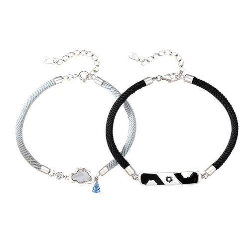 Two sterling silver bracelets, one with a cloud-shaped charm and a blue crystal, and the other with a black and white design featuring a star.