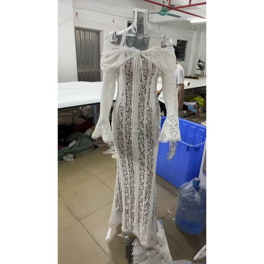 An off-shoulder white sheath dress with flared sleeves and lace details displayed on a mannequin.