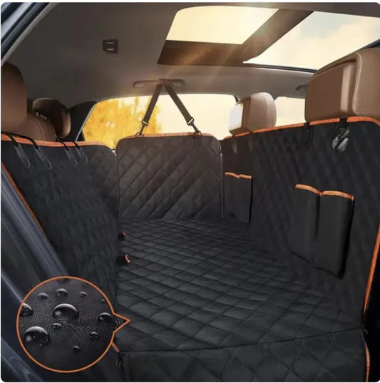 A black Oxford cloth car pet seat cover with orange edges installed in the back seat of a vehicle, featuring a double pocket design.