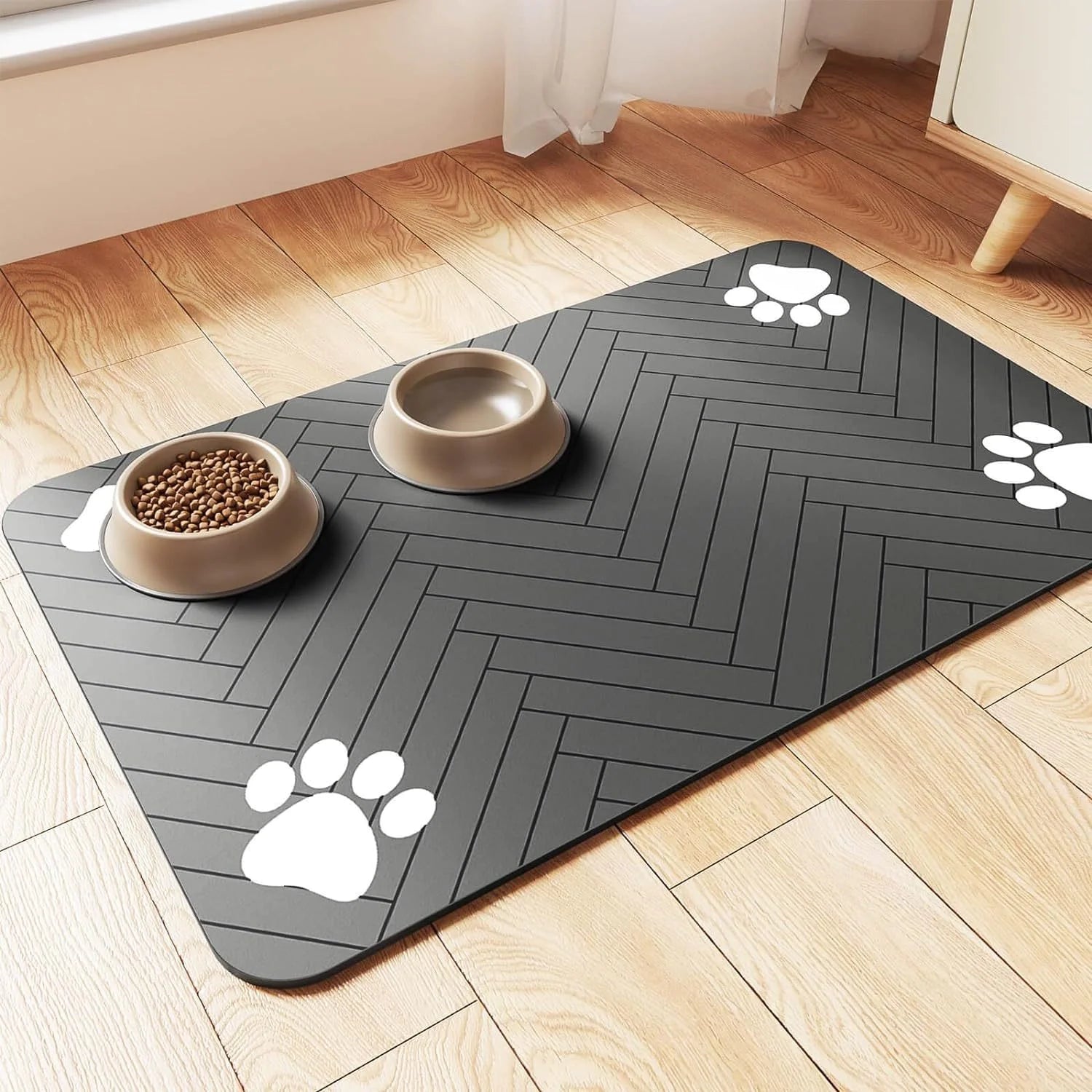 A black pet feeding placemat with a non-slip design, featuring bowls of food and water placed on top.