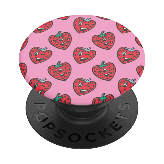 A PopSockets phone grip with a pink background featuring a pattern of cartoon strawberry characters with faces.