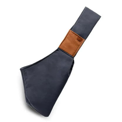 A portable crossbody cat carrier bag in navy blue with a brown leather accent.