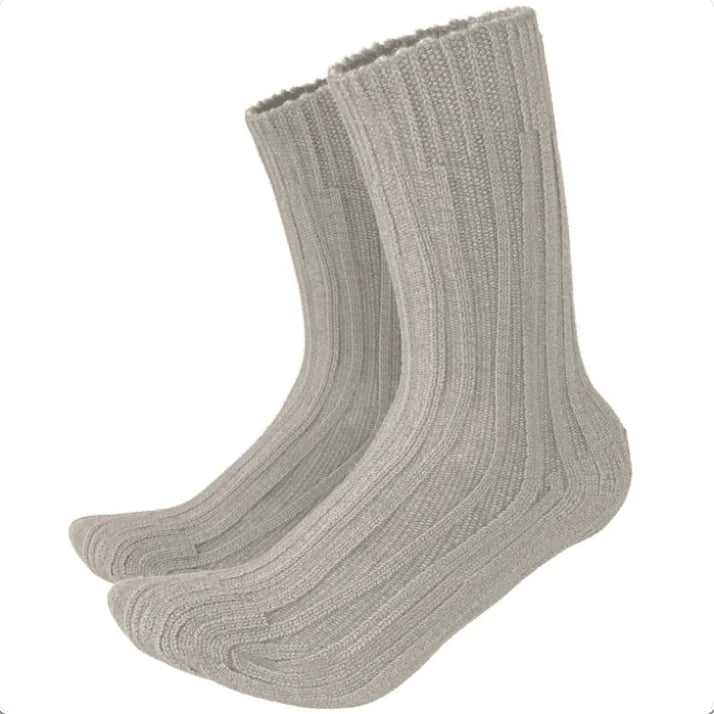 A pair of beige alpaca wool socks with the brand label showing the name 'Alpaca socks' and some additional text.