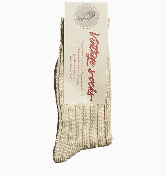 A pair of beige alpaca wool socks with the brand label showing the name 'Alpaca socks' and some additional text.