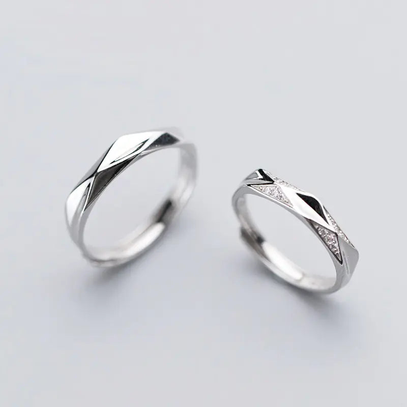 A pair of S925 silver rings, one with a larger band and the other with a smaller band, both featuring a grooved design.
