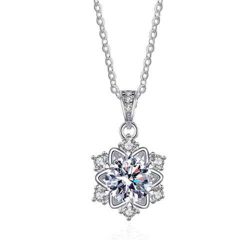 A sterling silver snowflake pendant necklace with a central moissanite or zircon crystal, surrounded by smaller clear crystals on a chain.