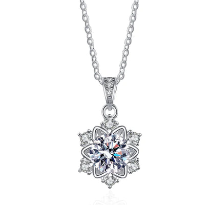 A sterling silver snowflake pendant necklace with a central moissanite or zircon crystal, surrounded by smaller clear crystals on a chain.