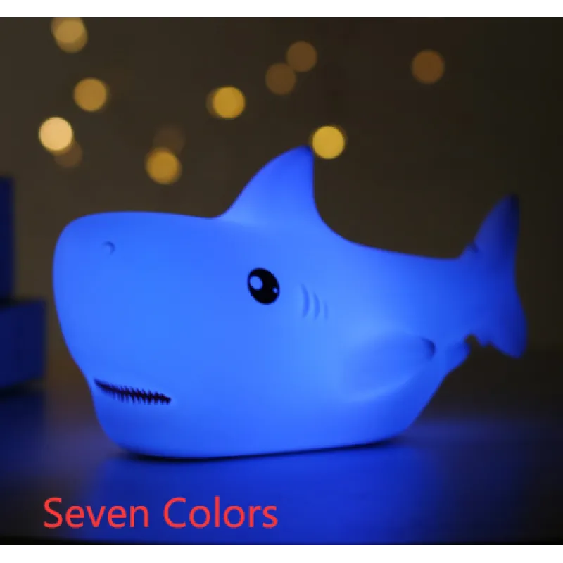 A blue LED night light designed in the shape of a shark, with the caption 'Seven Colors' indicating the number of available lighting modes.